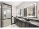 Elegant bathroom featuring dual vanities, illuminated mirrors, and gold hardware at 9029 Rivers Edge Dr, Las Vegas, NV 89117