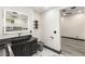 Modern bathroom featuring a black vanity with gold hardware and illuminated mirror over marble floors at 9029 Rivers Edge Dr, Las Vegas, NV 89117
