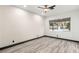 An empty bedroom featuring hardwood floors, a modern ceiling fan, and a window with views of the outdoors at 9029 Rivers Edge Dr, Las Vegas, NV 89117