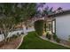 Landscaped front yard featuring green turf, gravel accents, and mature trees at 9029 Rivers Edge Dr, Las Vegas, NV 89117