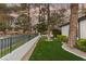 Well-manicured front yard with artificial turf, desert landscaping, and mature trees along the perimeter of the property at 9029 Rivers Edge Dr, Las Vegas, NV 89117