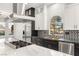 Contemporary kitchen features black and white cabinetry, stainless steel appliances, and eat-in island at 9029 Rivers Edge Dr, Las Vegas, NV 89117