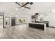 Bright, open living space with modern gray floors, a stylish kitchen, and views of the backyard at 9029 Rivers Edge Dr, Las Vegas, NV 89117
