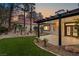 Covered patio with a view of lush landscaping, mature trees, and a neatly maintained artificial lawn at 9029 Rivers Edge Dr, Las Vegas, NV 89117