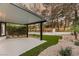 Covered patio featuring manicured greenery, rock landscaping, and a view of the backyard's perimeter wall at 9029 Rivers Edge Dr, Las Vegas, NV 89117