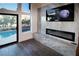 Modern living area with fireplace, television, and backyard pool access via sliding glass door at 912 Pro Players Dr, Las Vegas, NV 89134