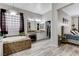 Bathroom features a tub with tile surround, dual sinks with vanity, walk-in closet access, and wood-look tile flooring at 9349 Olympia Falls Ave, Las Vegas, NV 89149