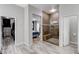 Bright primary bathroom features a tiled walk-in shower with a bench, neutral paint, and wood-look tile flooring at 9349 Olympia Falls Ave, Las Vegas, NV 89149