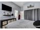 Cozy bedroom featuring a TV, mounted shelf, storage console, and an ensuite bathroom for added convenience at 9349 Olympia Falls Ave, Las Vegas, NV 89149
