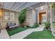 Private courtyard featuring a fountain, seating, and lush artificial turf at 9349 Olympia Falls Ave, Las Vegas, NV 89149