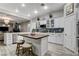 Well-lit kitchen with white cabinets, modern appliances, an island with seating, and a stylish backsplash at 9349 Olympia Falls Ave, Las Vegas, NV 89149