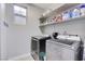Functional laundry room with a modern washer and dryer, complemented by storage shelves at 9349 Olympia Falls Ave, Las Vegas, NV 89149