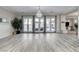 Expansive living room with wood-look floors, elegant chandelier, and patio access at 9349 Olympia Falls Ave, Las Vegas, NV 89149