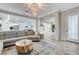 Bright living room with a plush grey sectional and views into the kitchen and entryway at 9349 Olympia Falls Ave, Las Vegas, NV 89149