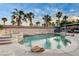 An inviting backyard pool with rock accents, a spa, a waterfall, and lush landscaping for a serene retreat at 9349 Olympia Falls Ave, Las Vegas, NV 89149