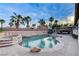 Inviting backyard oasis with a large pool, rock features, palm trees, and seating areas perfect for relaxing at 9349 Olympia Falls Ave, Las Vegas, NV 89149