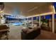 Covered patio offers shaded seating near the sparkling pool and rock waterfall feature at 9349 Olympia Falls Ave, Las Vegas, NV 89149