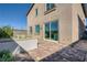 This backyard features brick pavers, a low wall, and sliding glass doors at 9564 Archer Peak Ct, Las Vegas, NV 89143