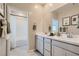 A bright bathroom includes double vanity with framed mirror and shower over tub at 9564 Archer Peak Ct, Las Vegas, NV 89143