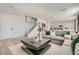 Open-concept living area with modern decor, a comfortable sofa, and seamless transition to the kitchen and staircase at 9564 Archer Peak Ct, Las Vegas, NV 89143