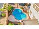 Aerial view showcases a large, uniquely shaped pool with surrounding concrete deck, plus a hot tub and lush landscaping at 977 Courtney Valley St, Henderson, NV 89052