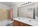 Bright bathroom featuring double sinks, large mirror and shower with pink curtain at 977 Courtney Valley St, Henderson, NV 89052