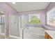 Bathroom featuring a large bathtub, shower, and a window to the outside at 977 Courtney Valley St, Henderson, NV 89052