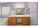 Bathroom featuring a large mirror, dual sinks, and lavender colored walls at 977 Courtney Valley St, Henderson, NV 89052