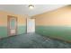 Empty bedroom with blue and beige accent walls, carpet, and door at 977 Courtney Valley St, Henderson, NV 89052