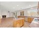 Open kitchen with tile floor, island, wood cabinets, and view of fireplace and living area at 977 Courtney Valley St, Henderson, NV 89052