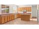 Bright kitchen featuring tile flooring, wood cabinets, and a center island at 977 Courtney Valley St, Henderson, NV 89052