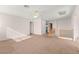 A spacious carpeted living room with staircase featuring natural light and neutral tones at 977 Courtney Valley St, Henderson, NV 89052