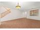 Living room with tile flooring, wood staircase, decorative light fixture, and front door at 977 Courtney Valley St, Henderson, NV 89052