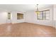 Bright living room with tile floors, windows with wood blinds and decorative hanging light fixture at 977 Courtney Valley St, Henderson, NV 89052