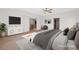 This staged main bedroom features ample light, decor, and a view into the hallway at 977 Courtney Valley St, Henderson, NV 89052
