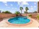 Sparkling in-ground pool with a spa, surrounded by lush landscaping and a brick fence providing a private oasis at 977 Courtney Valley St, Henderson, NV 89052