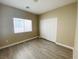 Neutral bedroom featuring wood-look flooring, a window, and closet with sliding doors at 9821 Sedona Shrine Ave, Las Vegas, NV 89148