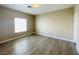 Spacious bedroom featuring wood-look flooring, a window, and neutral walls at 9821 Sedona Shrine Ave, Las Vegas, NV 89148