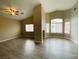 Open-concept living room featuring wood-look flooring, vaulted ceilings, and large windows at 9821 Sedona Shrine Ave, Las Vegas, NV 89148