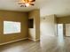 Bright living room with wood-look flooring, ceiling fan, and natural light from a large window at 9821 Sedona Shrine Ave, Las Vegas, NV 89148