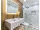 Modern bathroom with a floating vanity, rainfall shower head, and white marble-style tiling at 9937 Whalers Landing Ct, Las Vegas, NV 89117