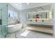 Luxurious bathroom with a soaking tub, a glass-enclosed shower, and marble countertops at 9937 Whalers Landing Ct, Las Vegas, NV 89117