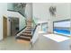 Bright open concept living area with high ceilings, staircase and view of pool at 9937 Whalers Landing Ct, Las Vegas, NV 89117