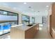 The modern kitchen features a large island, sleek cabinetry, and direct access to the pool at 9937 Whalers Landing Ct, Las Vegas, NV 89117