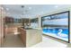 Modern kitchen featuring a center island, sleek appliances, and large windows overlooking the pool at 9937 Whalers Landing Ct, Las Vegas, NV 89117