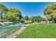 Calm pond view with natural rock edging, surrounded by lush green landscaping and mature trees at 9937 Whalers Landing Ct, Las Vegas, NV 89117