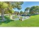 Scenic view of a pond surrounded by lush green grass and mature trees, providing a tranquil setting at 9937 Whalers Landing Ct, Las Vegas, NV 89117
