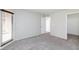A light-filled bedroom with neutral walls, plush carpet and a door leading to a private balcony at , Las Vegas, NV 89120