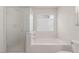 Bright bathroom features a soaking tub with glass shower door and frosted windows at 104 Big Cliff Ave, North Las Vegas, NV 89031