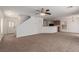 Open-concept living room with carpet, white walls, open staircase and kitchen in the background at 104 Big Cliff Ave, North Las Vegas, NV 89031